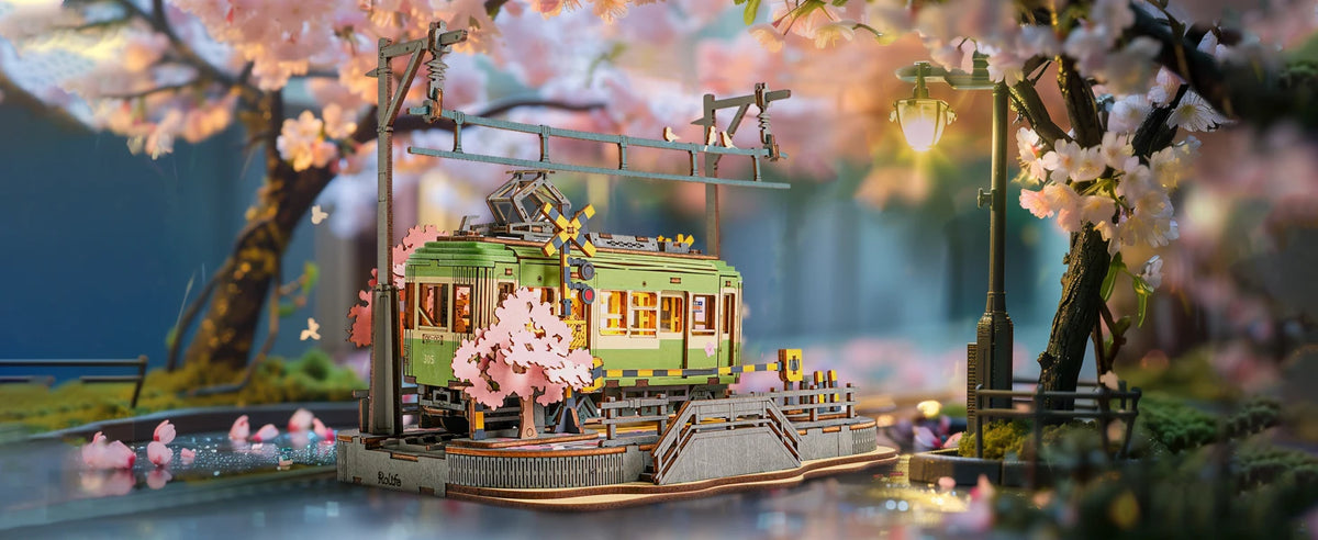 Detaljert trepuslespill av trikk på skinner omgitt av rosa kirsebærblomster og grøntområder.