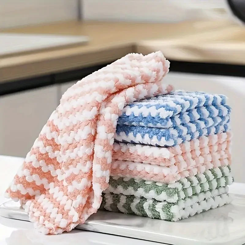 Montón de paños de limpieza de vellón coral en rosa y azul sobre una superficie blanca.