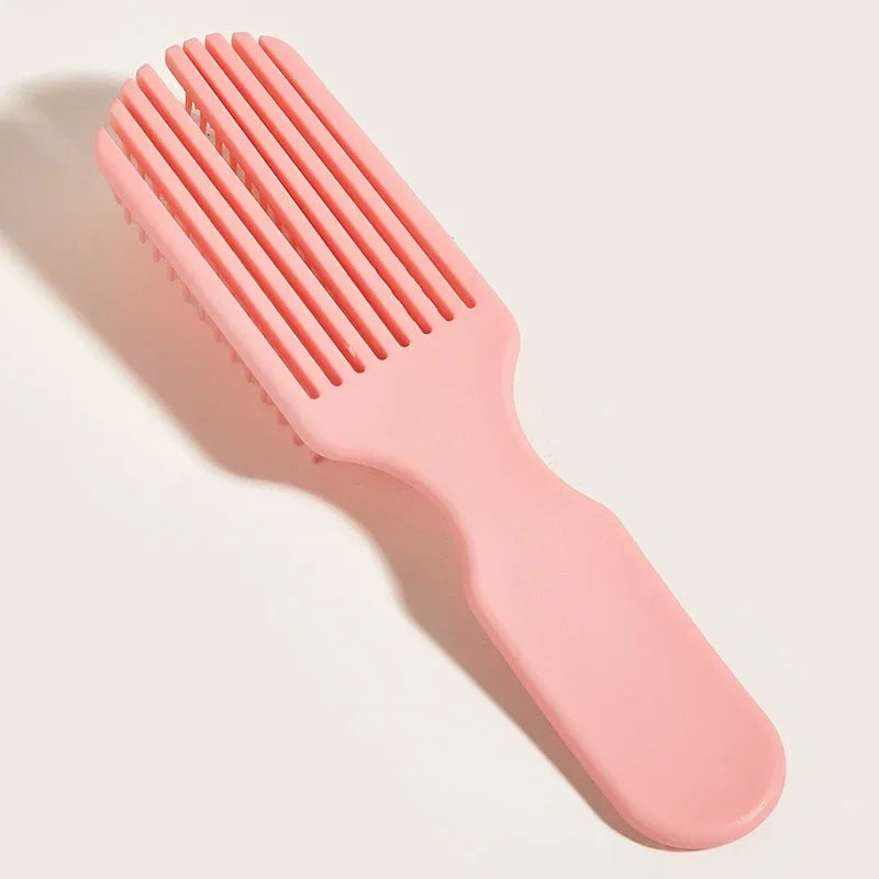 Peine rosa de 9 púas para masaje capilar y desenredado, sobre una superficie clara.