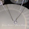 Silver crystal bow angel wings heart pendant necklace displayed on a light surface.