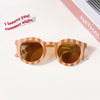 Pair of kids polarized sunglasses with a light brown striped frame and amber lenses on a white background.