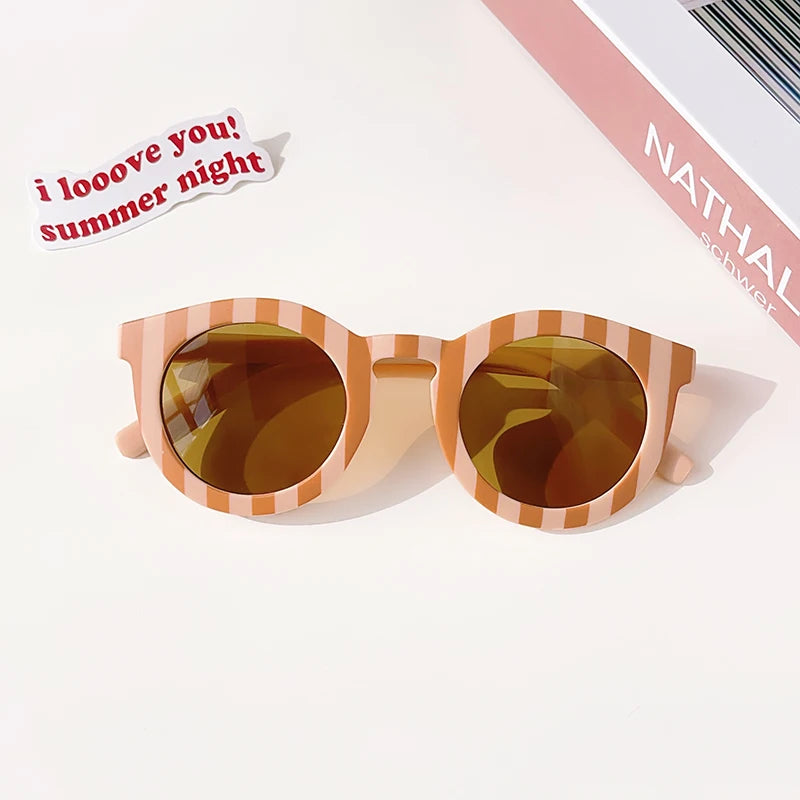 Pair of kids polarized sunglasses with a light brown striped frame and amber lenses on a white background.