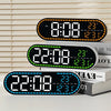 A black digital wall clock displaying time, temperature, and day of the week, resting on a stack of books.