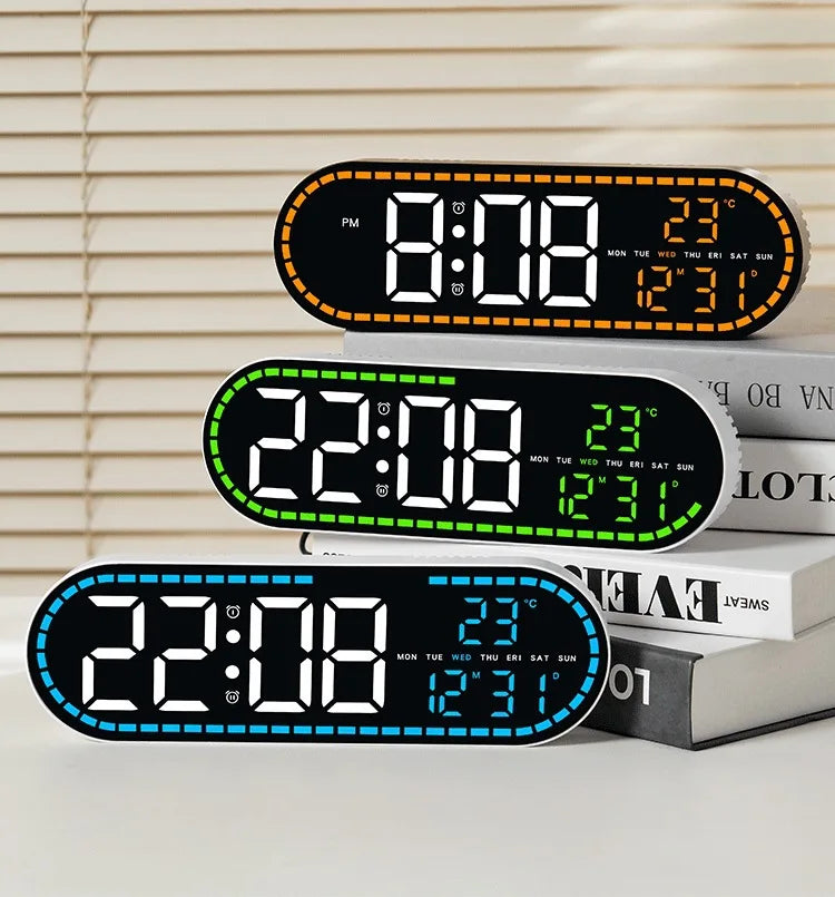 A black digital wall clock displaying time, temperature, and day of the week, resting on a stack of books.