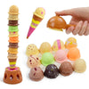 A hand is holding a plastic ice cream cone and a round ice cream, alongside a stacked ice cream toy set.