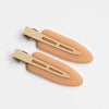 A set of two matte resin side hair clips in a nude or peach color, shown against a white background.