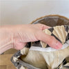A hand is holding up kids' washed cotton harem pants with pockets, showing the fabric and stitching.