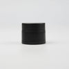 A black jar of refillable travel face cream with a leak-proof lid.