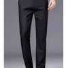 Black men's stretch straight-leg trousers worn by a man, paired with a white shirt and a silver watch.