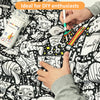 Hands are coloring a black and white patterned blanket with markers.