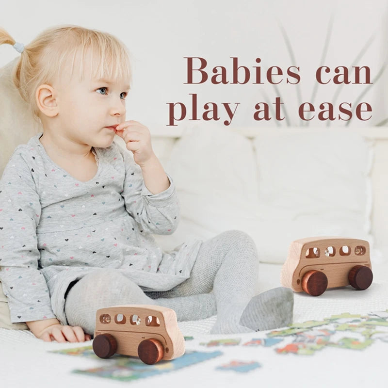 A baby is playing with a hand-pushed wooden cart toy on a white surface.