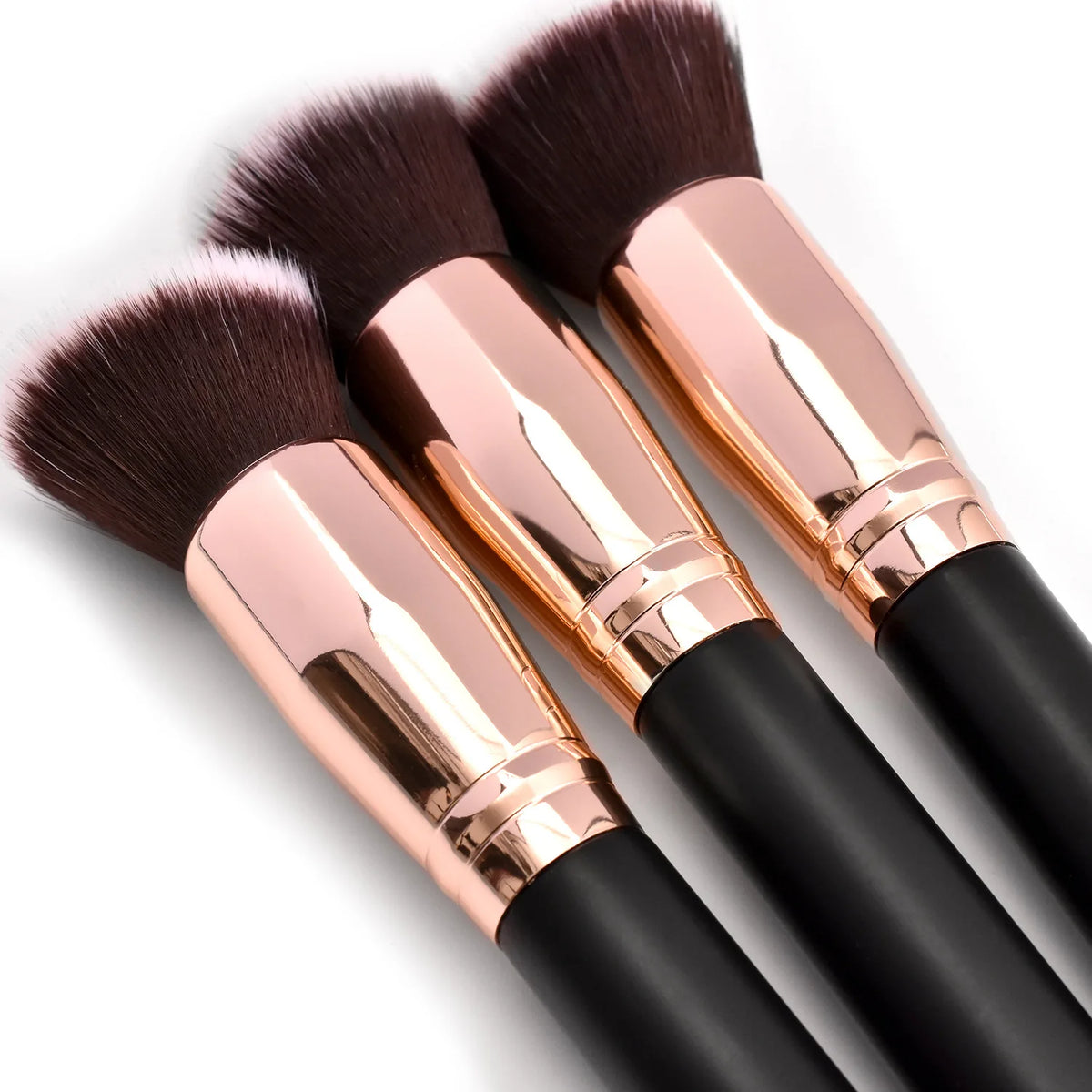 A pair of professional makeup brushes with pink gold handles and dark bristles for foundation, concealer, and blush applicati