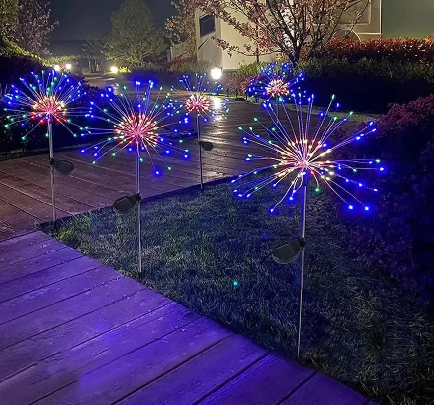 Colorful LED fireworks display in the night featuring bright blue and pink sparks shooting into the air.