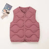 A pink quilted vest for a child is shown next to a stuffed animal.