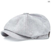 A light gray vintage newsboy cap with a folded brim shown from the side.