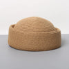 A woven straw pillbox sun hat in a natural tan color shown against a gray background.