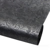 Roll of black faux leather fabric with silver floral texture for crafting projects