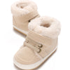 A pair of beige, shearling-lined baby winter snow boots for toddlers.