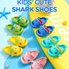 A collection of colorful kids shark clog sandals in green, blue, and yellow on a bright background.