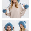 A woman models a light blue knitted hooded scarf with fluffy trim and a face mask.