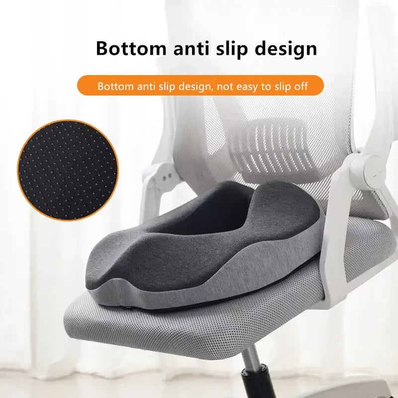 En grå minneskum-donutsittepute i en hvit kontorstol, med sklisikker design.