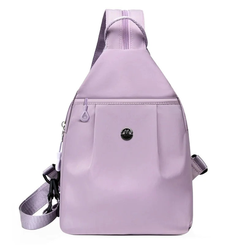 A light purple mini backpack with a zipper closure and adjustable strap.