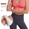 A woman models a coral sports bra with wide shoulder straps, demonstrating its fit and removable design.