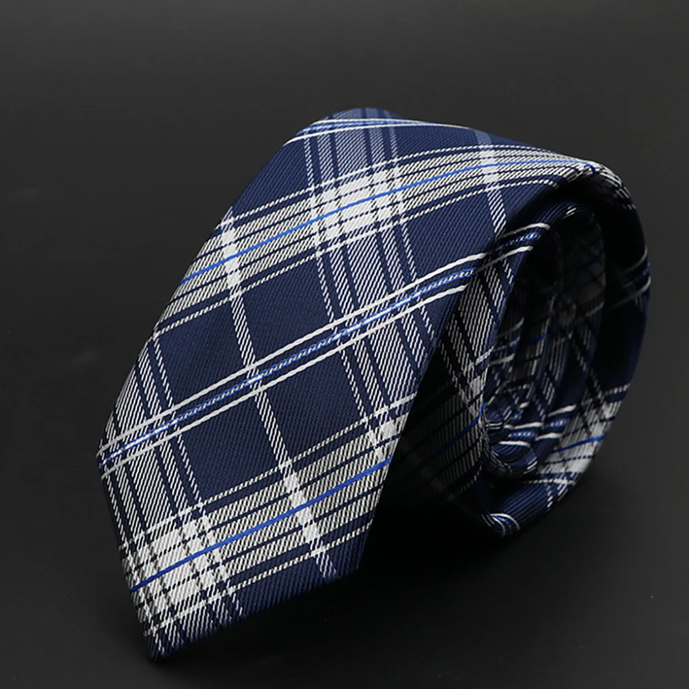 Corbata de cuadros azul oscuro y blanca, doblada sobre un fondo negro.