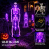 Violetti LED-luuranko puutarhavalo valaisemassa pelottavaa Halloween-asetelmaa.
