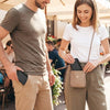 A man and a woman standing together, looking at a minimalist card holder wallet.