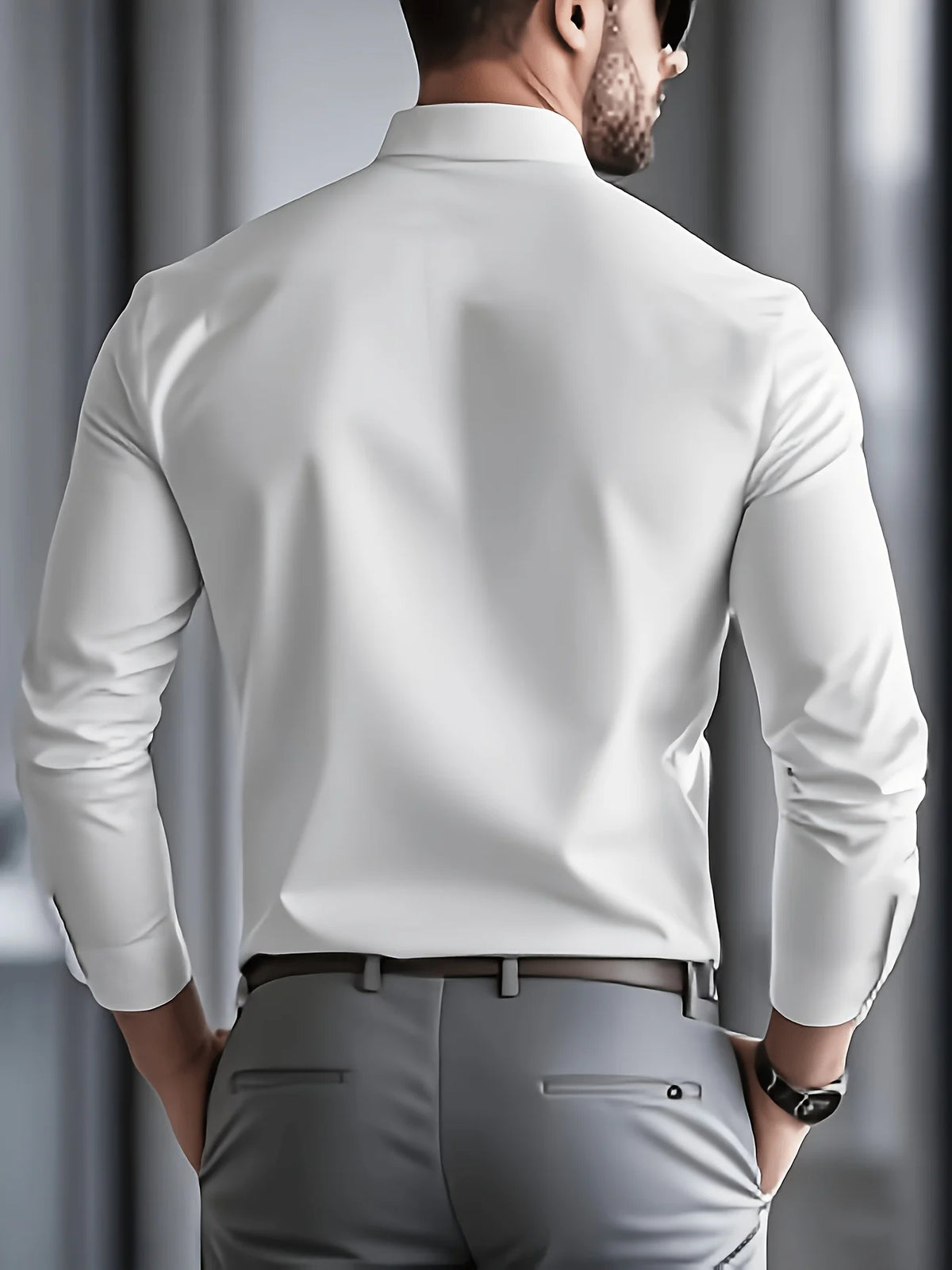 A man wearing a white long-sleeve formal shirt and gray trousers, viewed from the back.