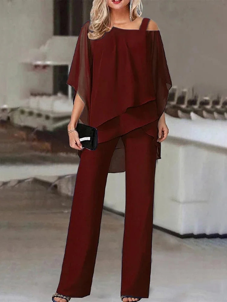 Kvinne modellerer et rødbrunt todelt sett med off-shoulder topp og vide bukser.