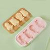 A wooden board holds silicone popsicle molds and a plastic tray filled with pink silicone popsicles.