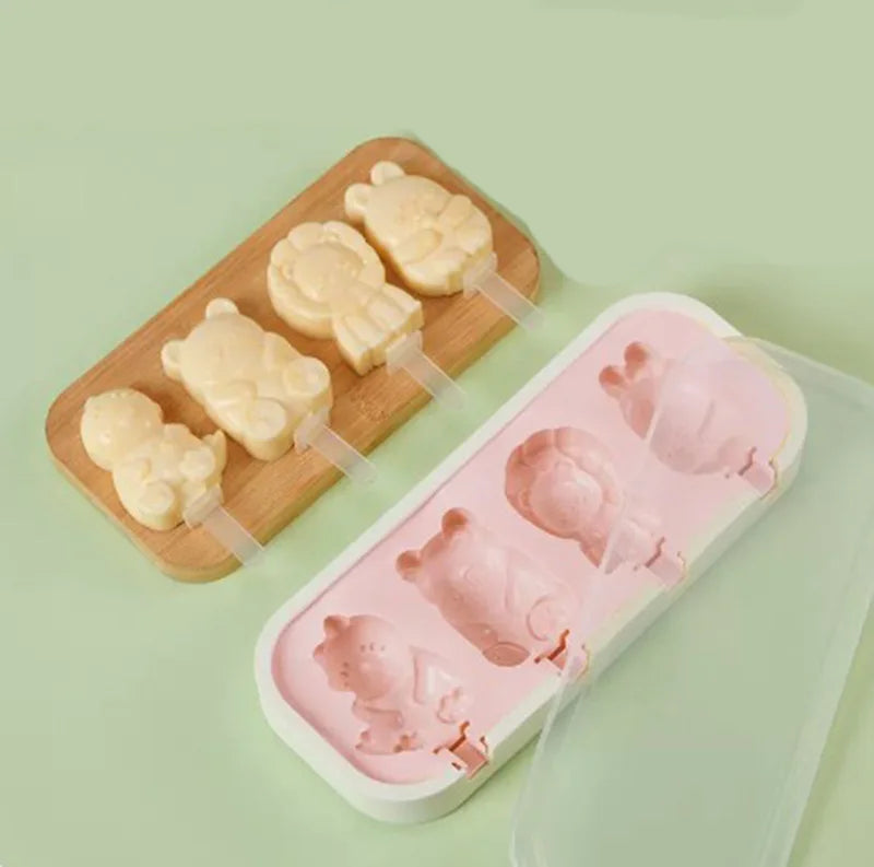 A wooden board holds silicone popsicle molds and a plastic tray filled with pink silicone popsicles.