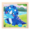 A wooden jigsaw puzzle featuring a cute blue dinosaur character against a green landscape.