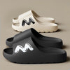 A pair of gray EVA slide slippers with a black wavy logo on the top