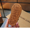 A close-up of a brown leather ankle boot sole with textured grip and the brand name embossed on it.