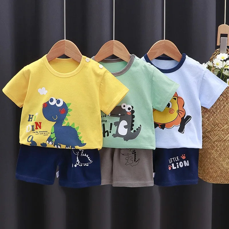 A set of yellow, mint green, and light blue dinosaur print short-sleeve t-shirts and shorts for children.