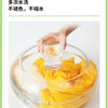 A hand is pouring water into a bowl filled with sliced yellow avocado fruit for washing.