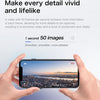 A hand holds a smartphone displaying a panoramic cityscape at sunset.