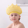 A young child wearing a yellow silicone baby shampoo crown with small spikes.