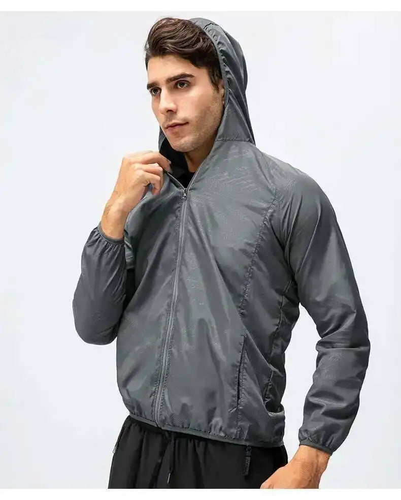 A male model wearing a gray waterproof windbreaker jacket with a hood and zipper.