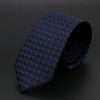 Corbata azul oscuro con diseño geométrico, enrollada sobre fondo oscuro.