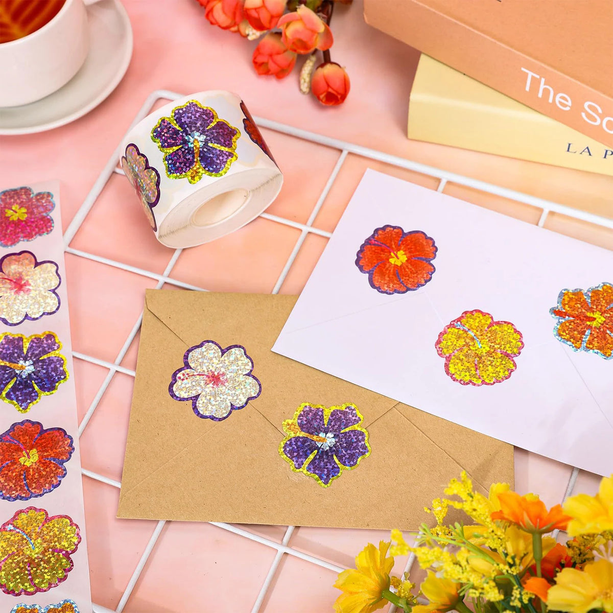 A collection of glitter flower round stickers in purple and orange are displayed on a white grid with craft supplies.