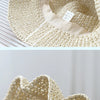 Close-up view of a beige crochet straw fisherman hat with a wide brim and woven texture.