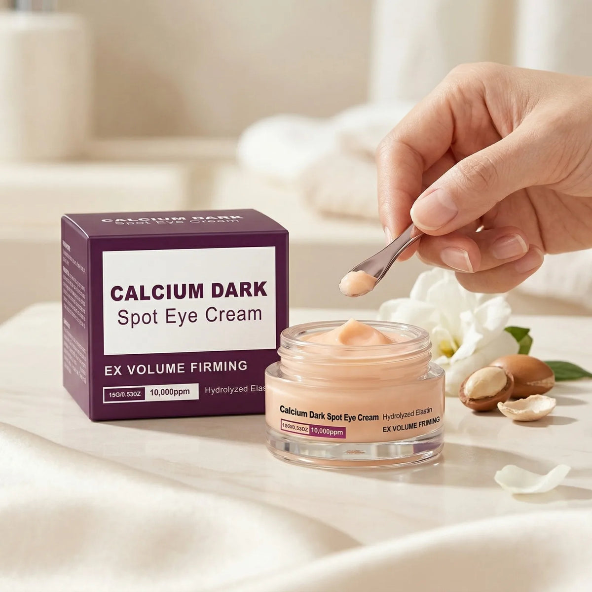A hand holds a jar of Calcium Dark Spot Eye Cream with a silver spoon on a white surface.
