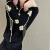 Gold butterfly zircon ear cuff with dangling gold tassels worn on a hand.