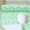 A light green anti-skid cloth mat with avocado print and a white layer shown on a wooden surface.