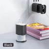 A black silicone charger protector and cable organizer with two charging tips mounted on a white wall.