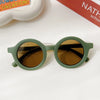 Olive green polarized sunglasses with brown lenses resting on a white surface.